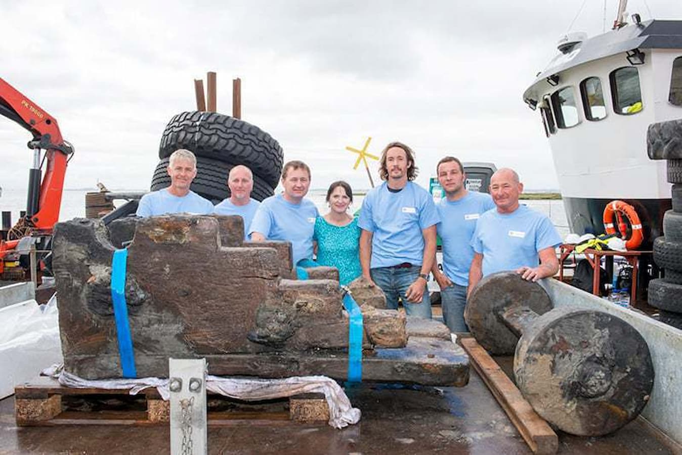 Members of the licensee and archaeological teams with the recovered gun carriage from the ship © Historic England