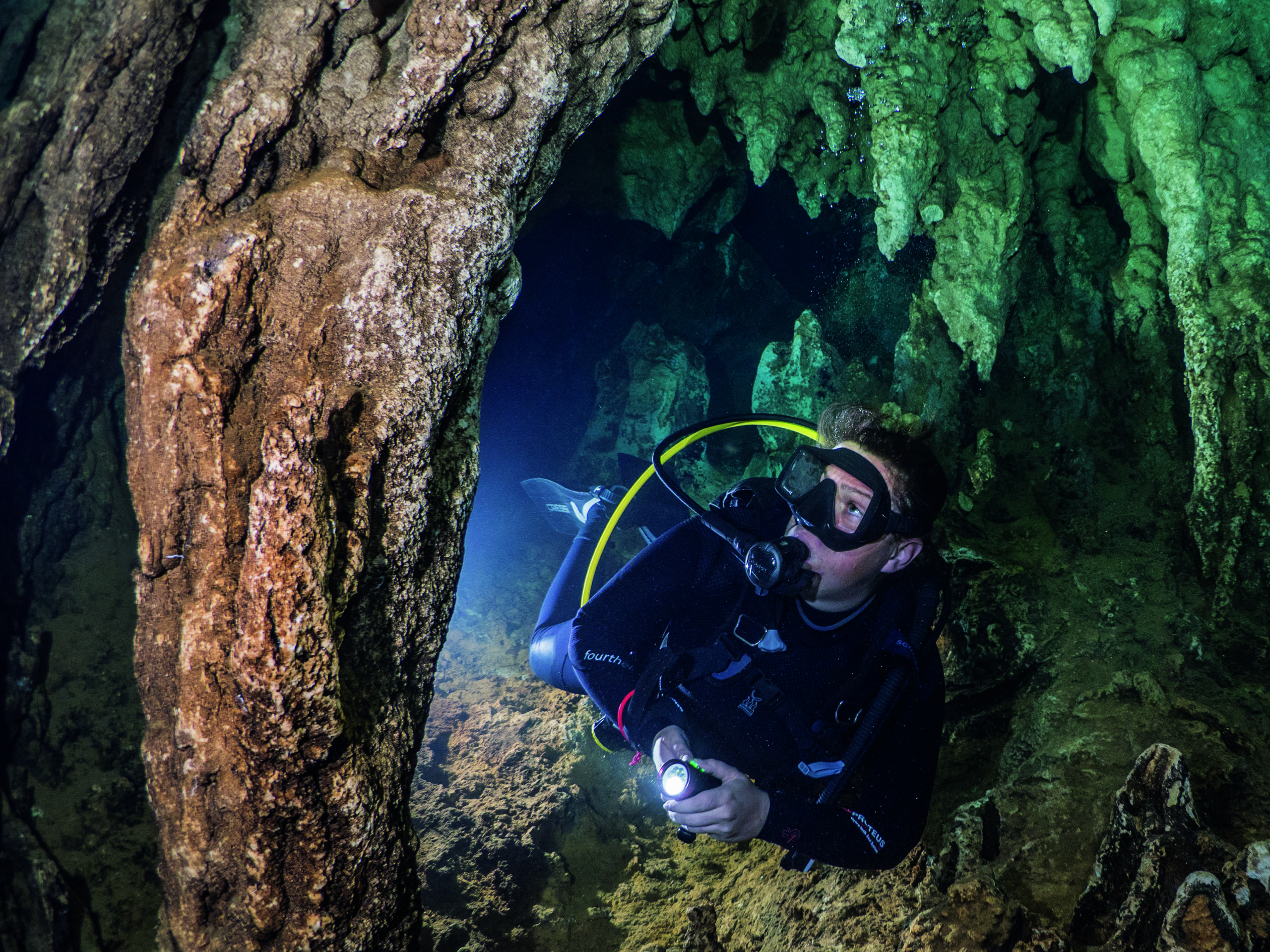A diver swims by a stalactite in Chandelier cave, Palau, where you can find some amazing rock formations. When using a diver in your image, make sure the eye line of your model goes to a focal point in your shot and not into the camera.