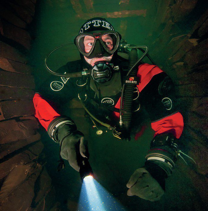 padi scuba diver swimming in tight space