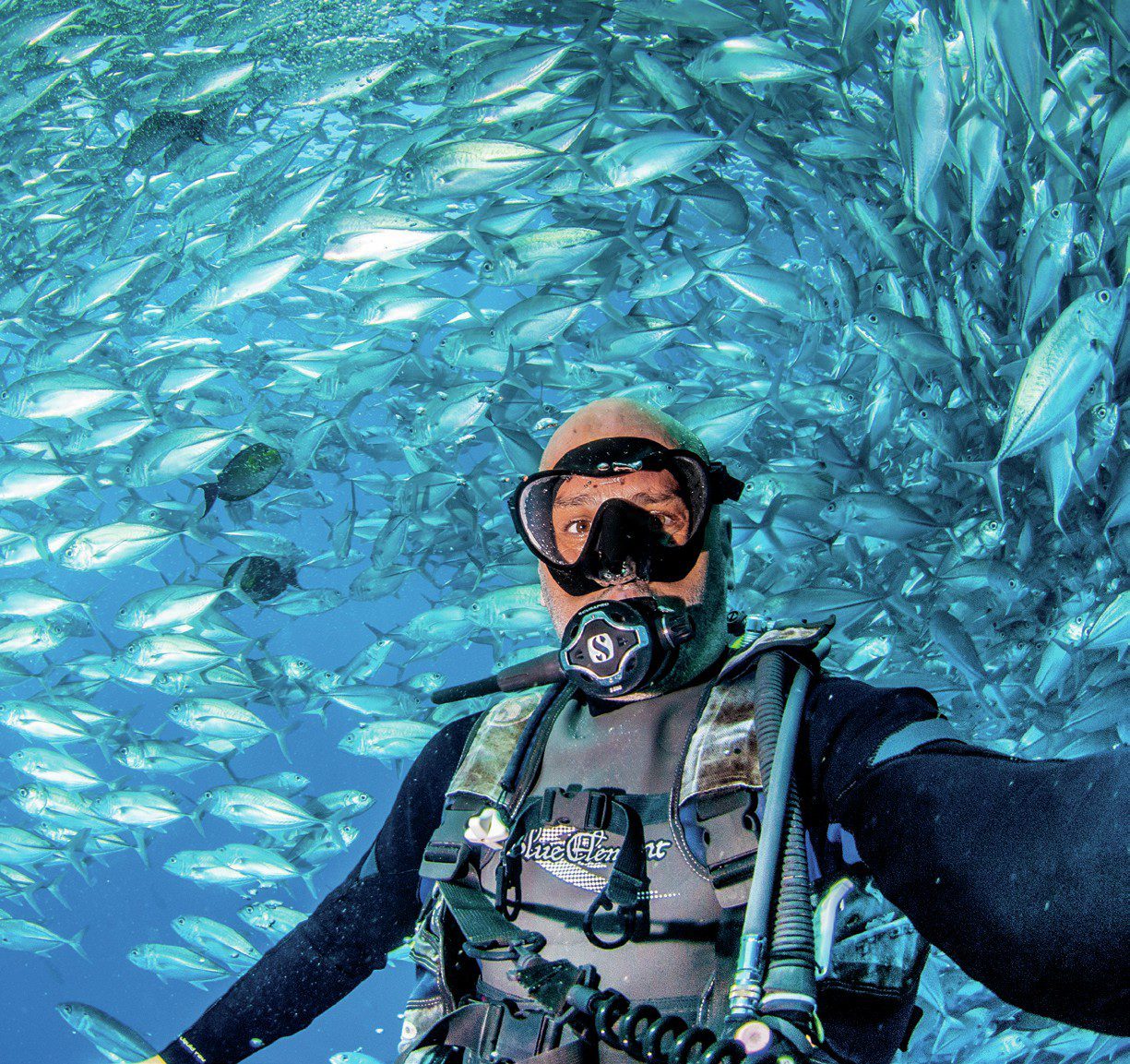 Scuba Diver taking selfie with jackfish school of fish