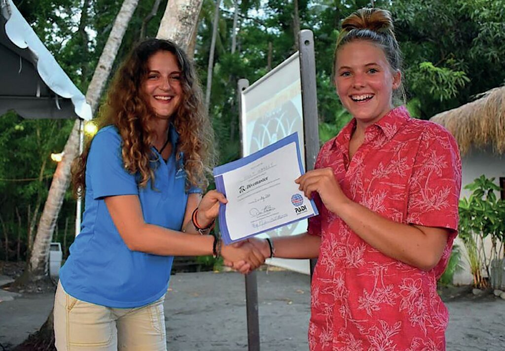 World first -Holly being presented with her PADI Junior Divemaster certificate