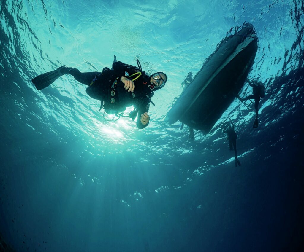 Divers under dive boat
