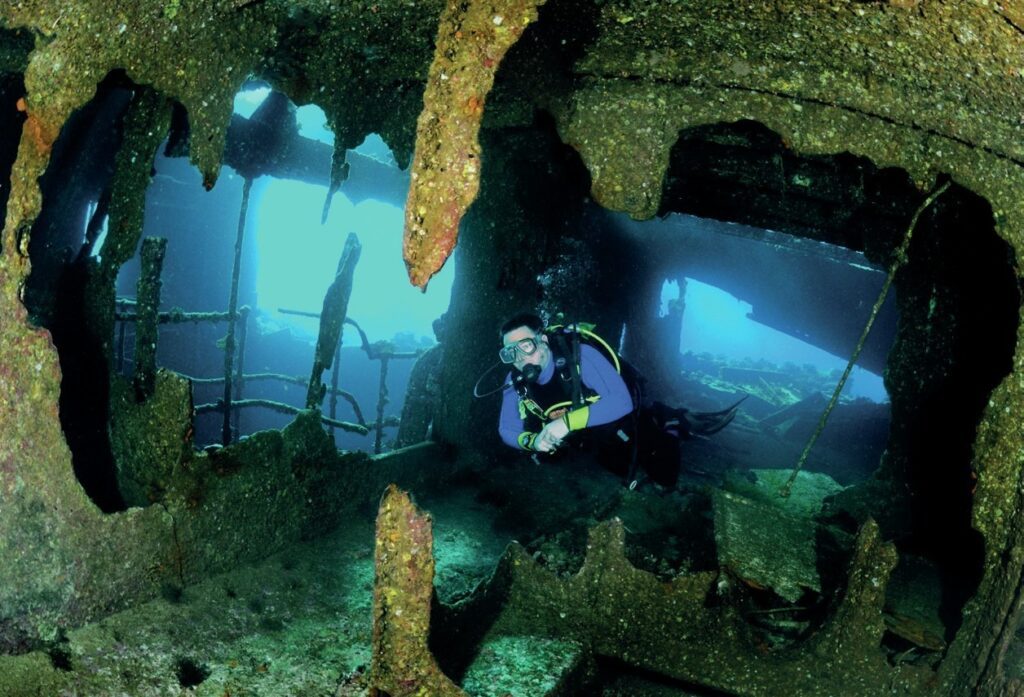 Scuba divers Exploring inside a shipwreck
