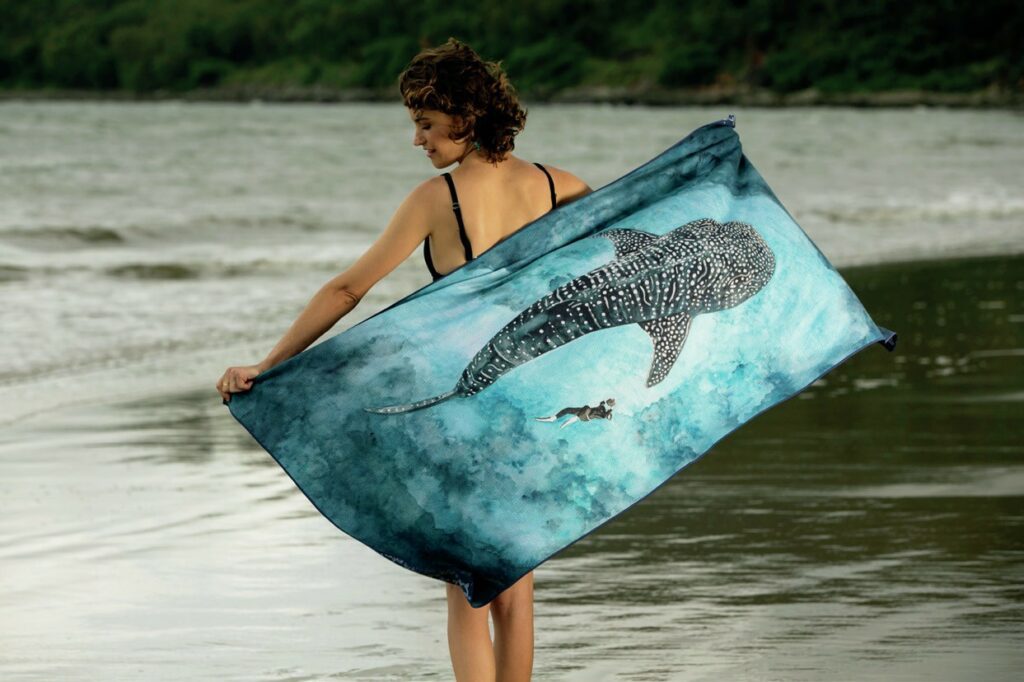 girl on beach with whale towel