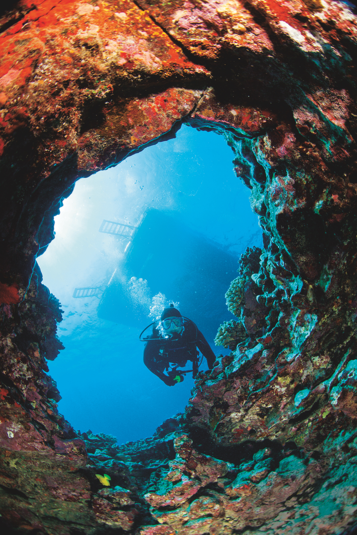 Diver entering a lava tube at the Amphitheater in Kona, Hawaii